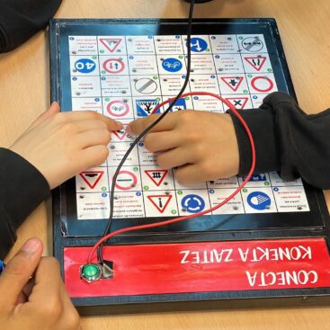 Manos de niños interactuando con un tablero de señales de tráfico en un Escape Room.