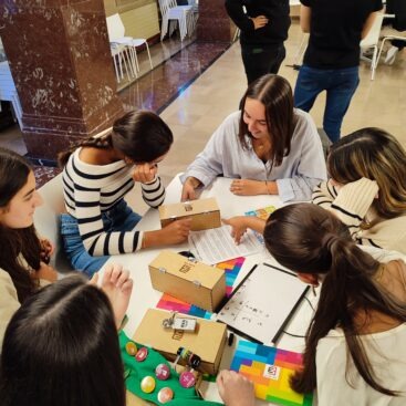 Grupo de personas colaborando en una actividad de team building en una sala iluminada.