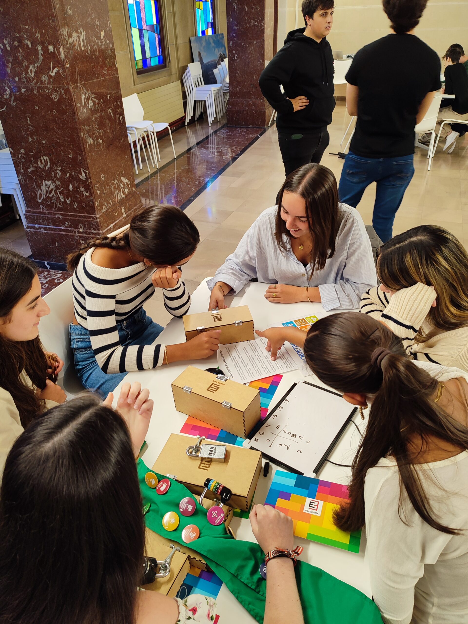 Grupo de personas colaborando en una actividad de team building en una sala iluminada.