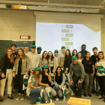 Grupo de jóvenes posando en un aula, con presentaciones y materiales sobre talento joven.